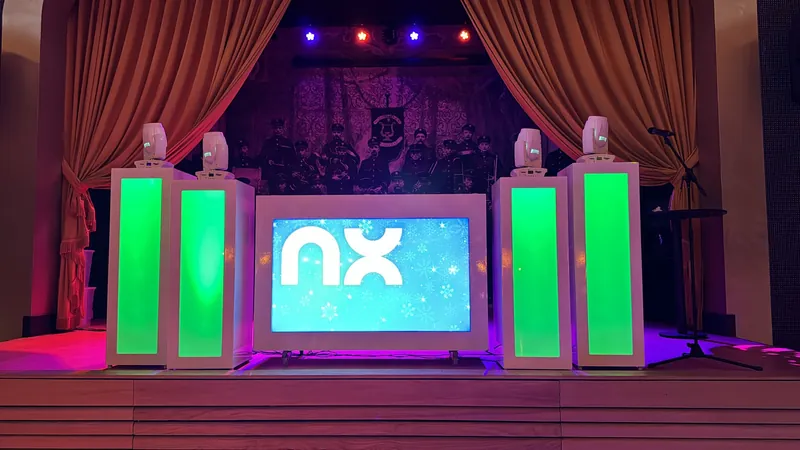 Witte DJ show van DJ Deliso met verlichte zuilen en scherm